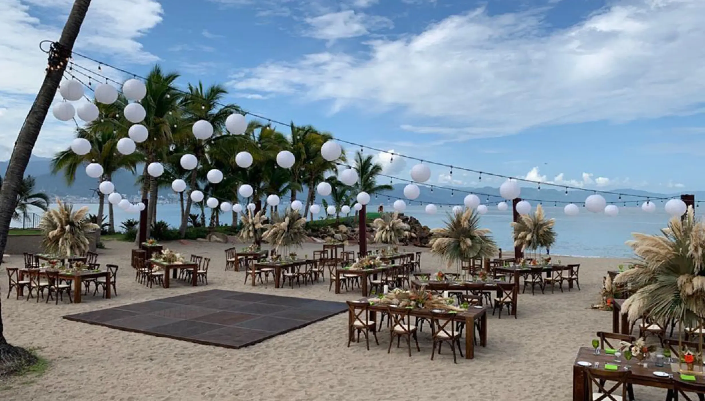 Beach wedding reception setup with string lights and dance floor at Marriott Puerto Vallarta