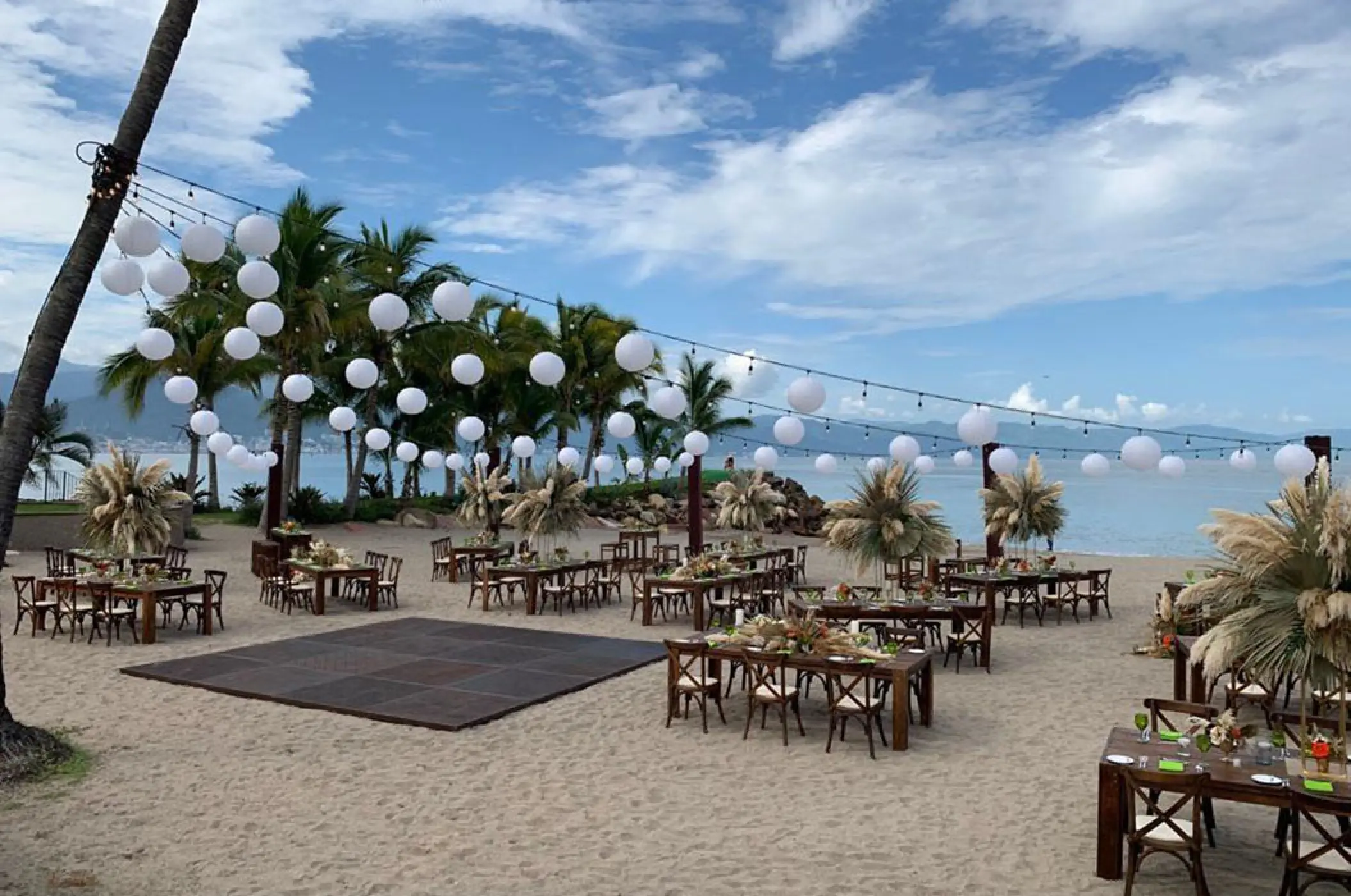 Beach wedding reception setup with string lights and dance floor at Marriott Puerto Vallarta