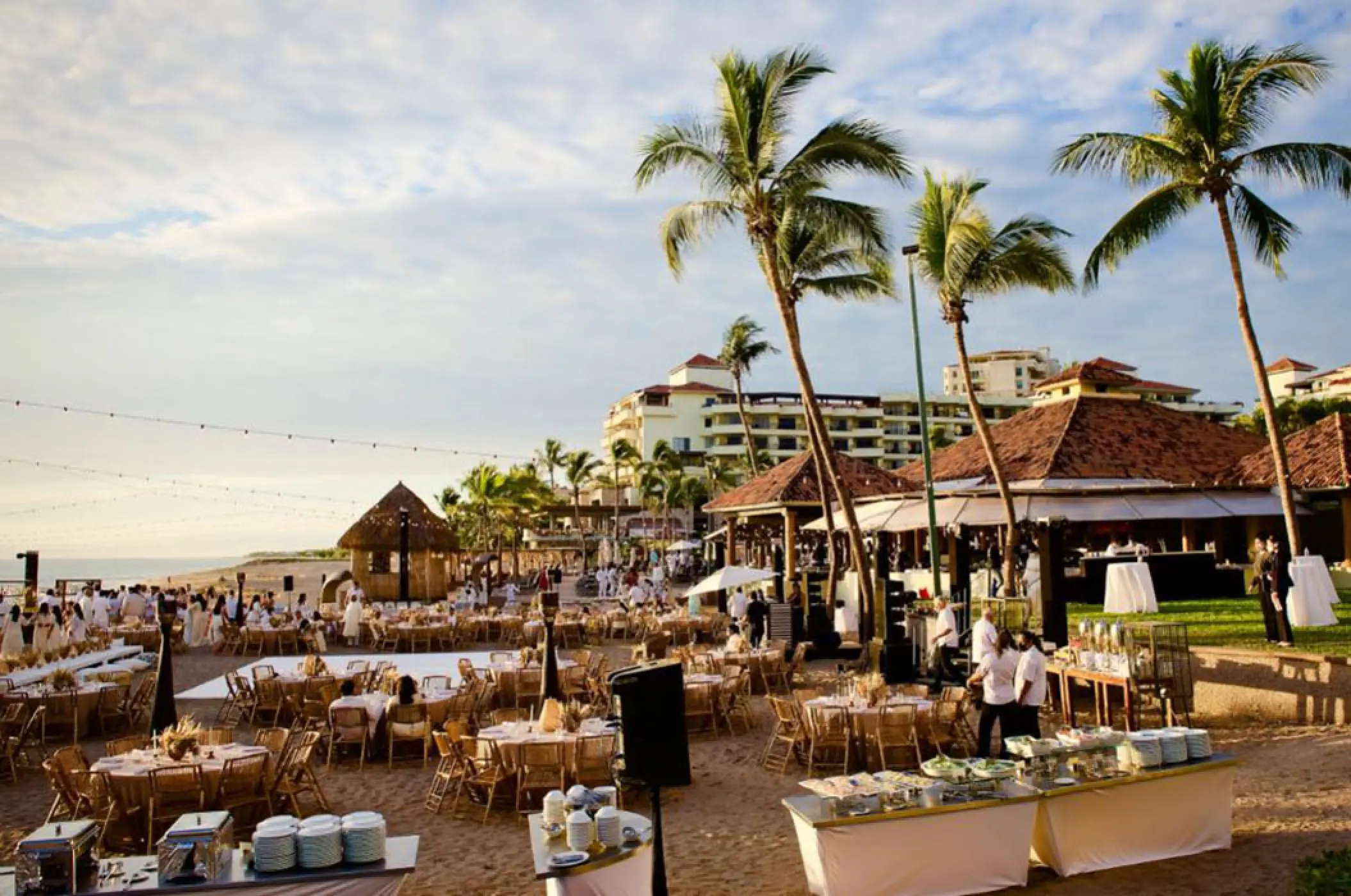 Beachfront wedding reception setup with round tables and palm trees at Marriott Puerto Vallarta