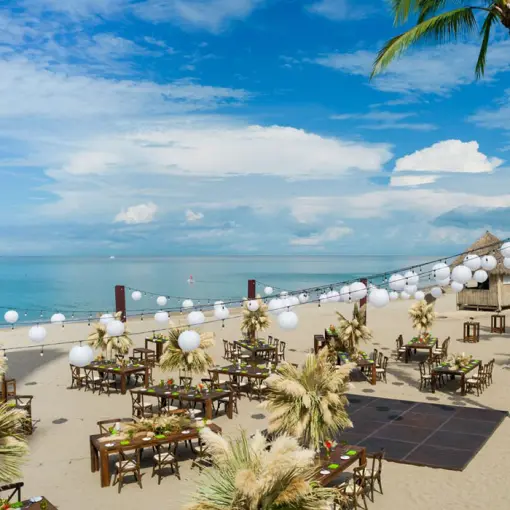 Beach wedding reception setup with paper lanterns and pampas grass at Marriott Puerto Vallarta
