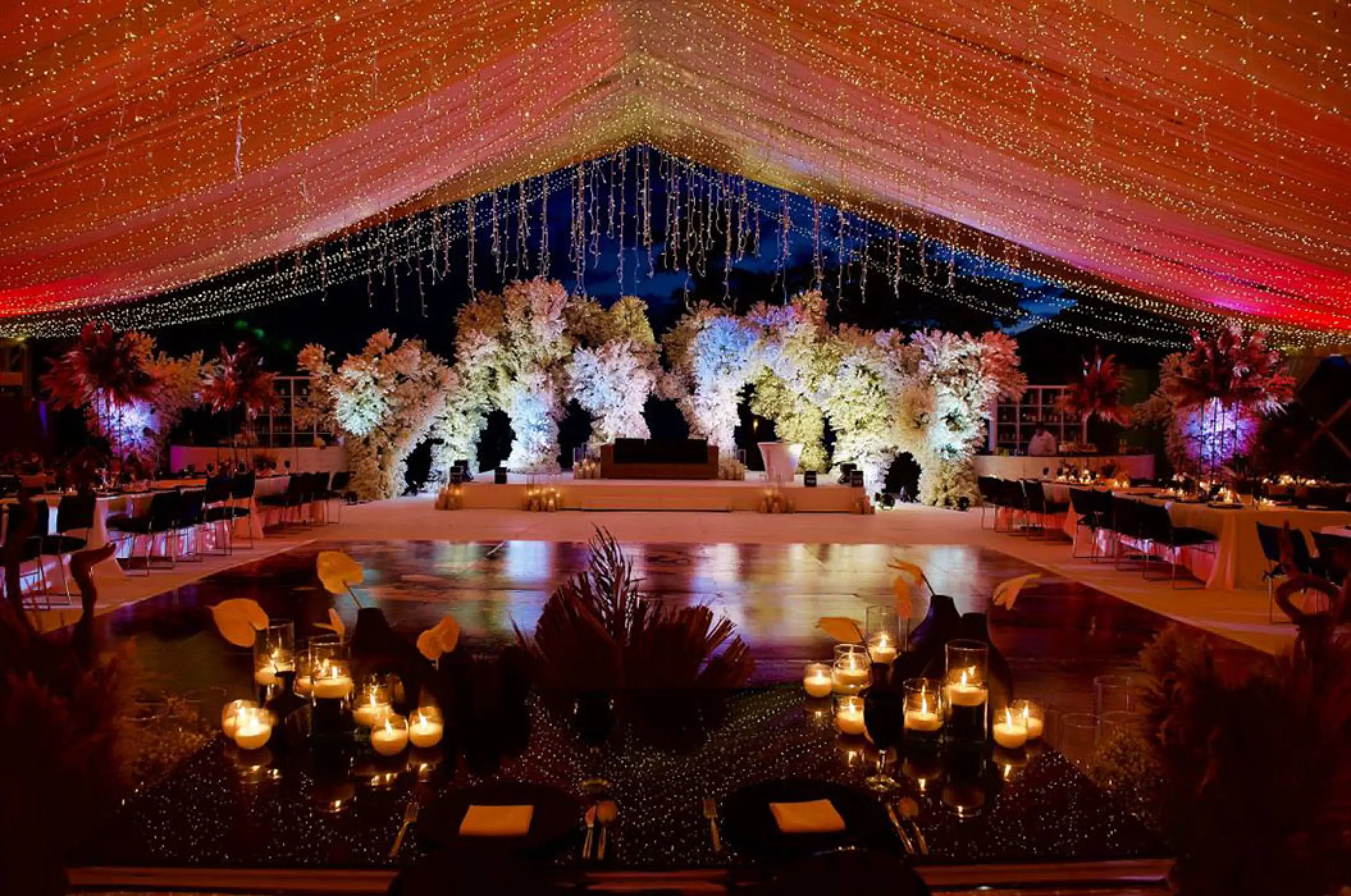 Evening wedding reception on the patio at Marriott Puerto Vallarta with fairy lights and white floral installations