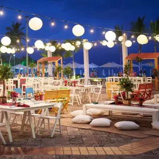 Evening wedding reception setup with string lights and white paper lanterns at Marriott Puerto Vallarta, Puerto Vallarta