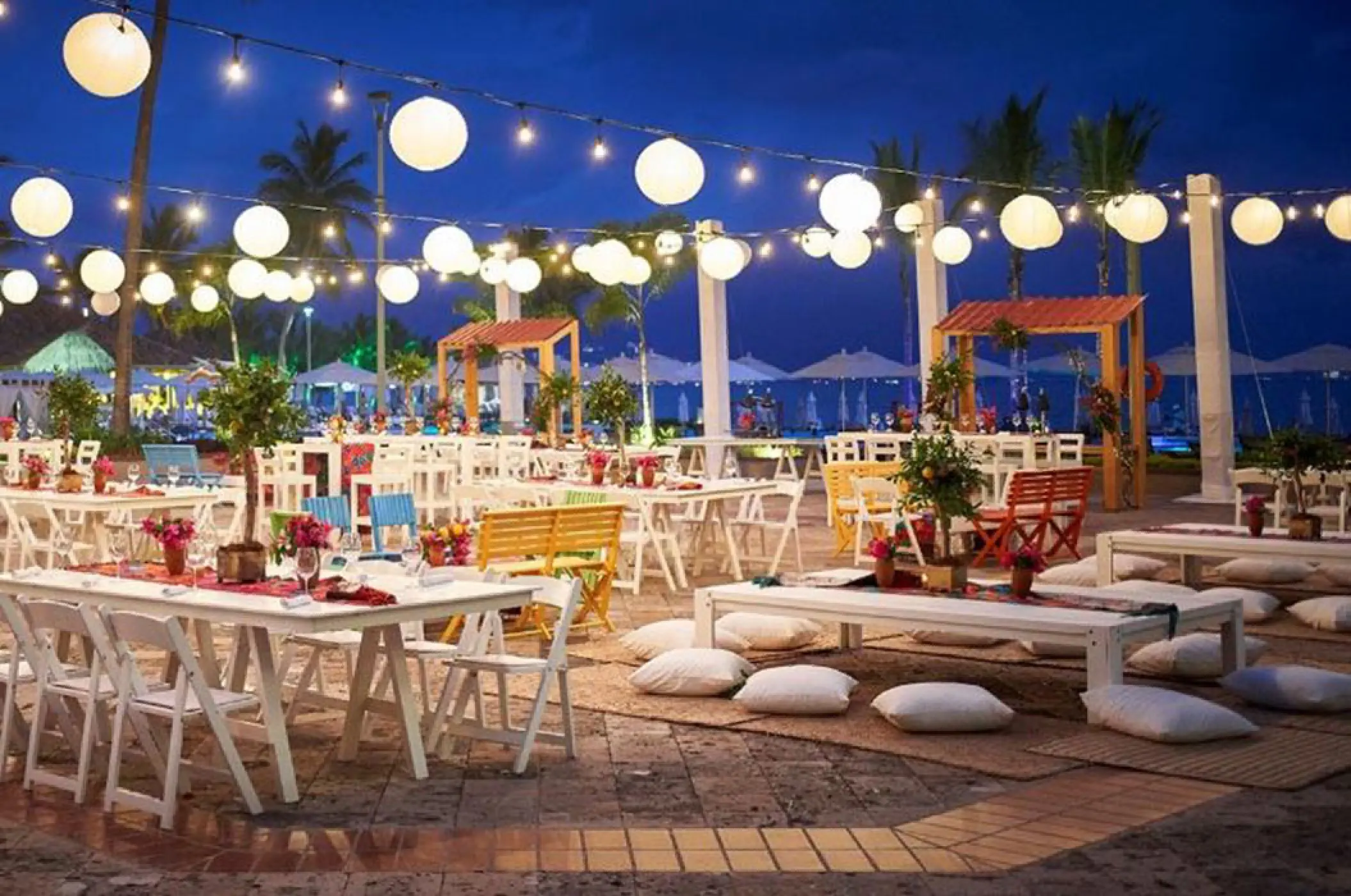 Evening wedding reception setup with string lights and white paper lanterns at Marriott Puerto Vallarta, Puerto Vallarta