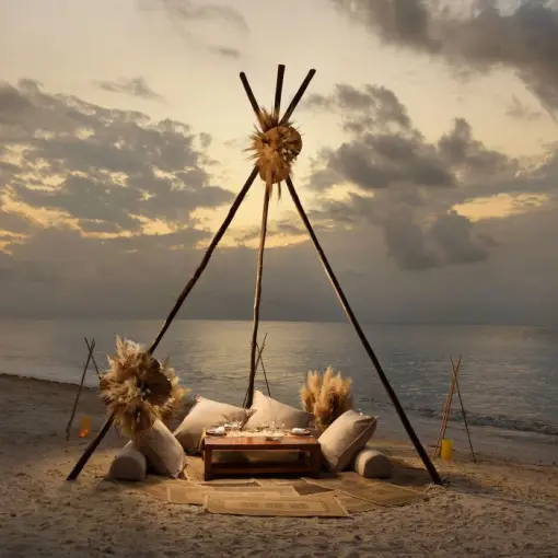 Boho beach dinner setup under a wooden teepee at Melia Cozumel, Cozumel