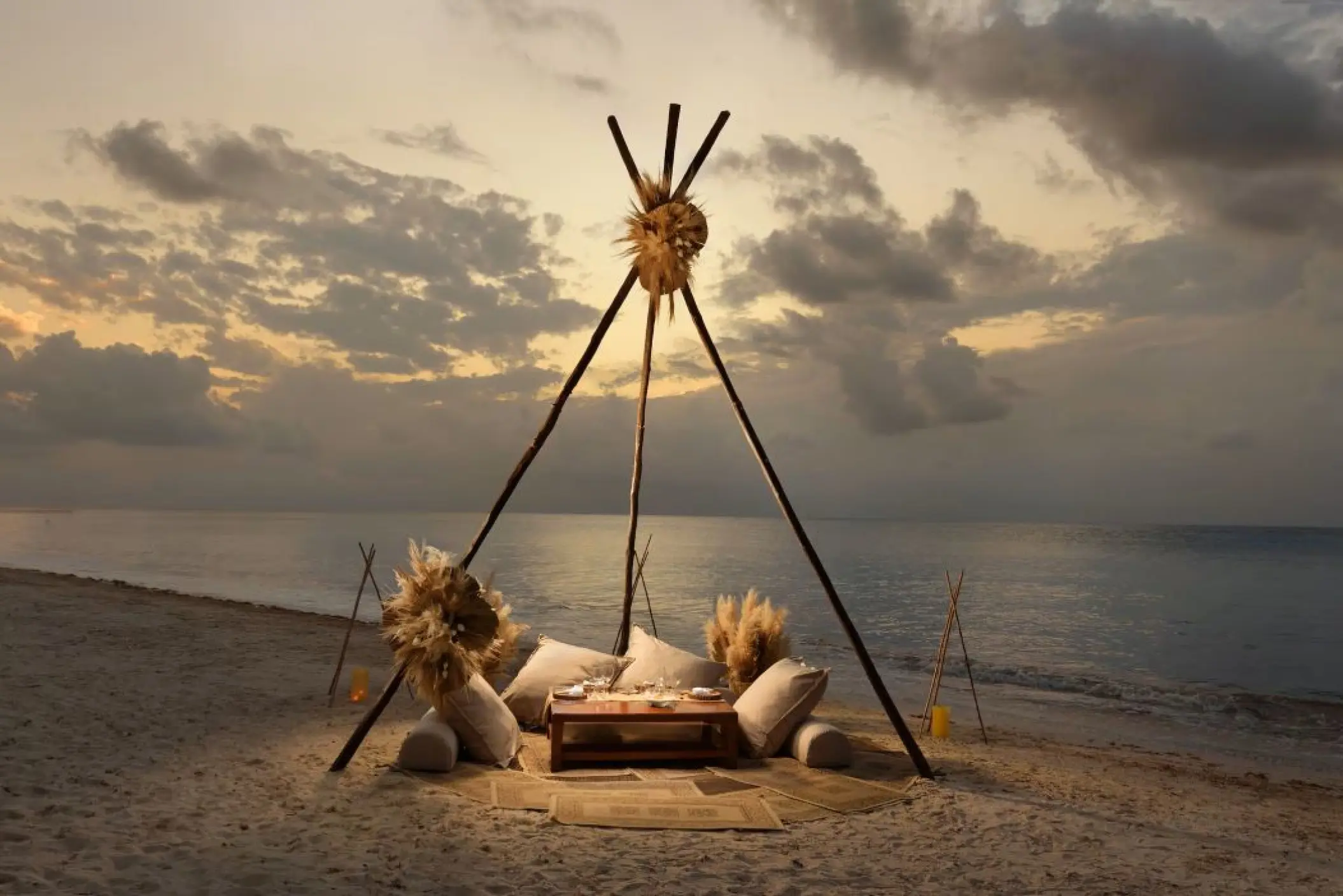 Boho beach dinner setup under a wooden teepee at Melia Cozumel, Cozumel