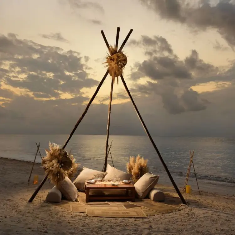 Boho beach dinner setup under a wooden teepee at Melia Cozumel, Cozumel