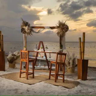 Beachfront wedding reception setup with a wooden bar and pampas grass at Melia Cozumel, Cozumel