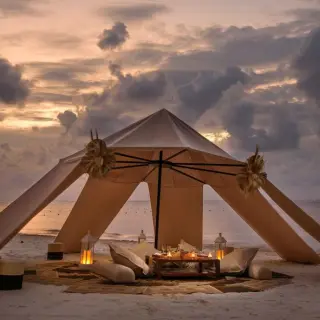 Beachfront wedding reception tent with floor seating and lanterns at Melia Cozumel, Cozumel
