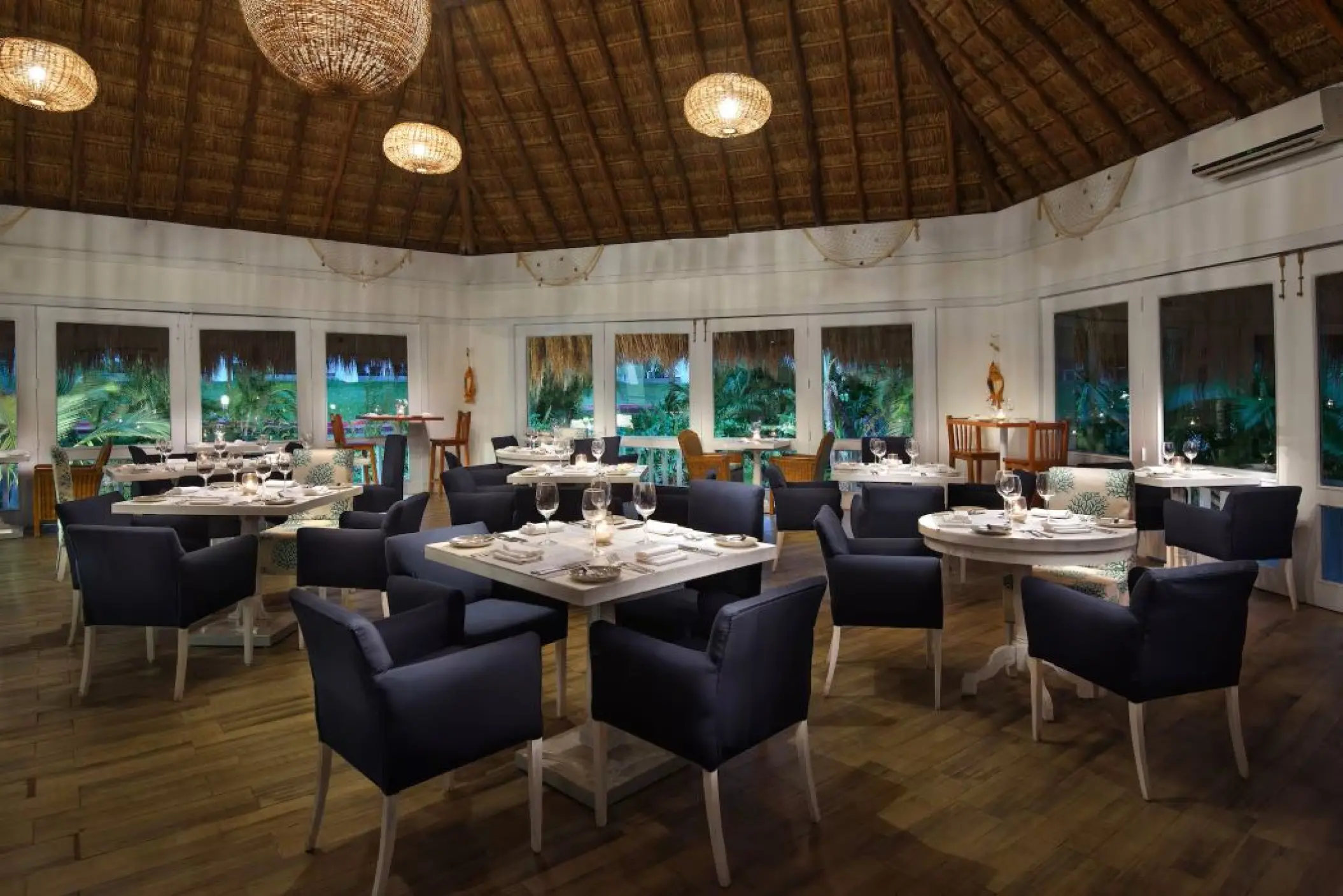 The Fish House restaurant dining area with thatched ceiling at Melia Cozumel, Cozumel