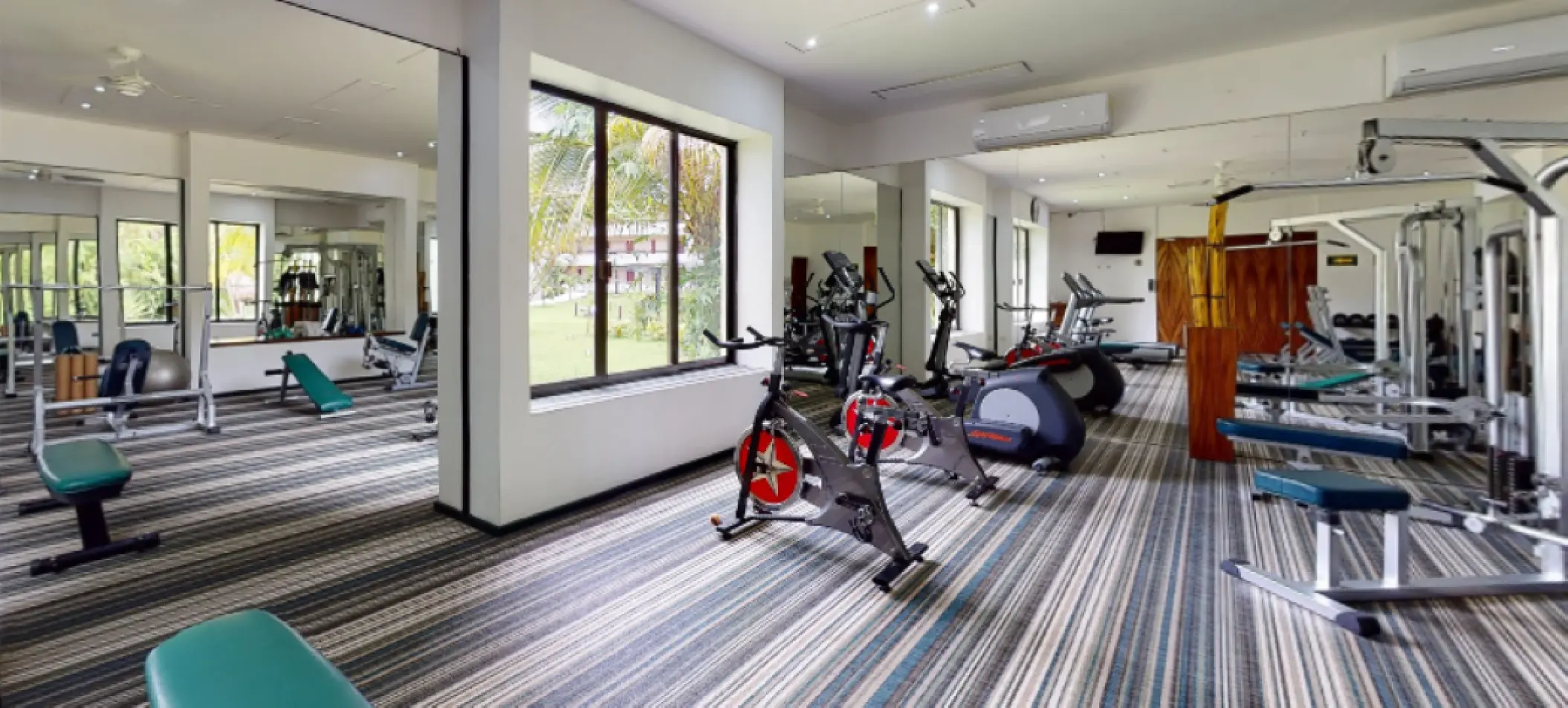 Fitness center with exercise bikes and weight machines at Melia Cozumel, Cozumel