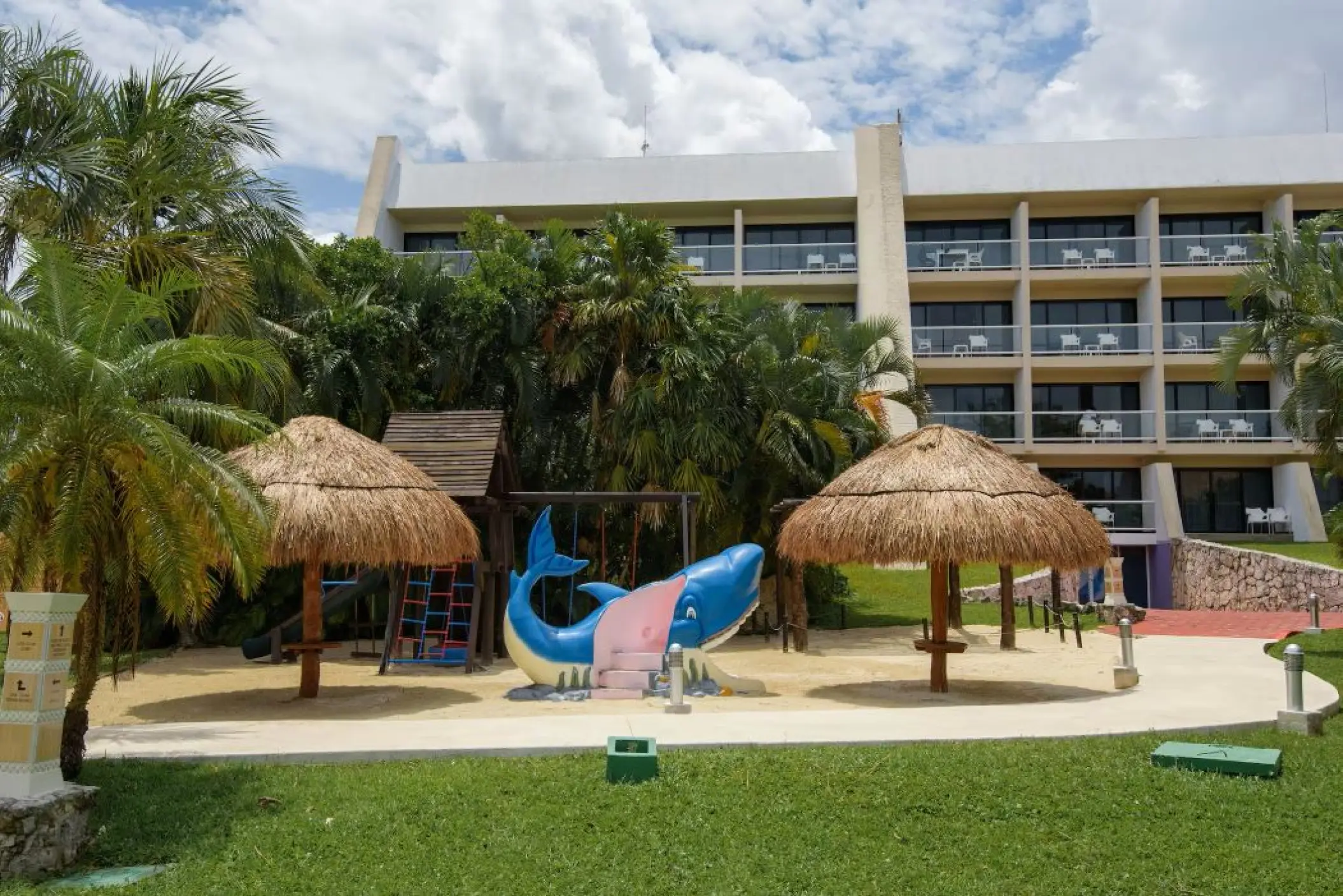 Kids playground with shark slide and thatched umbrellas at Melia Cozumel