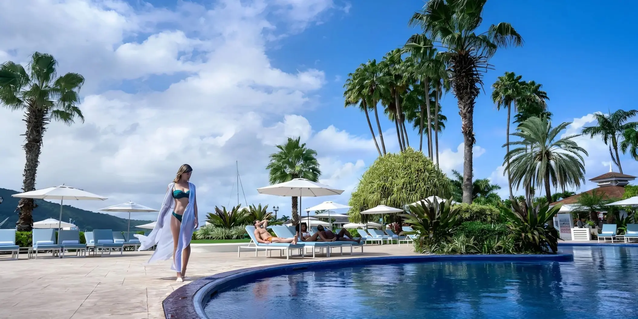 Woman in a white cover-up walking by the pool at Moon Palace Jamaica, Ocho Rios