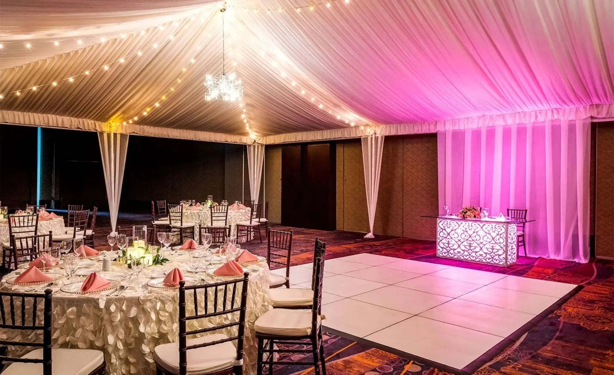 Indoor ballroom wedding reception with white dance floor and pink lighting at Moon Palace Jamaica, Ocho Rios