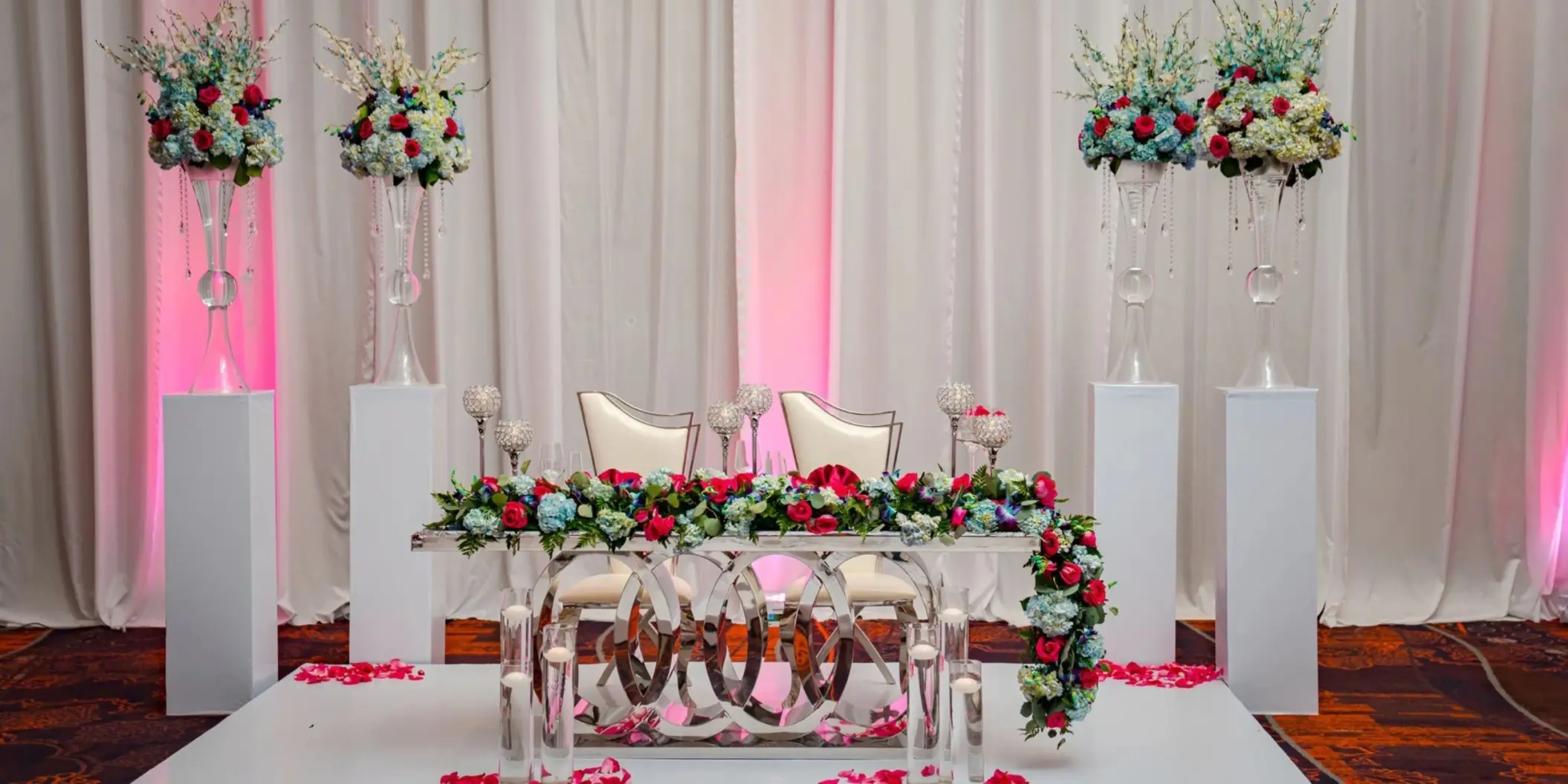 Ballroom wedding reception sweetheart table with red and blue flowers at Moon Palace Jamaica, Ocho Rios