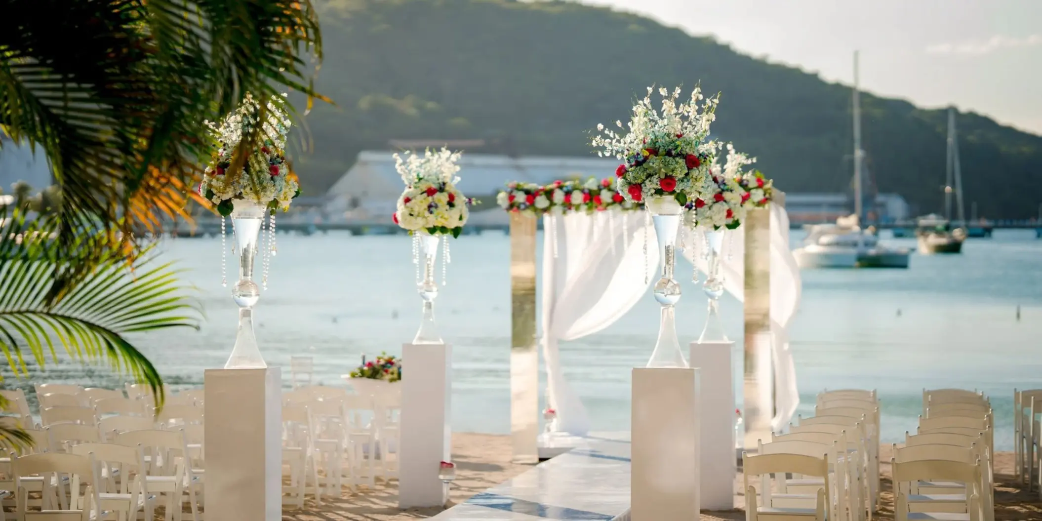 Beachfront wedding ceremony with white floral arch at Moon Palace Jamaica, Ocho Rios