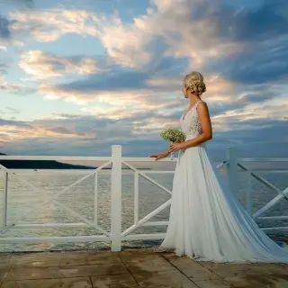Bride holding a bouquet by the ocean at sunset at Moon Palace Jamaica, Ocho Rios