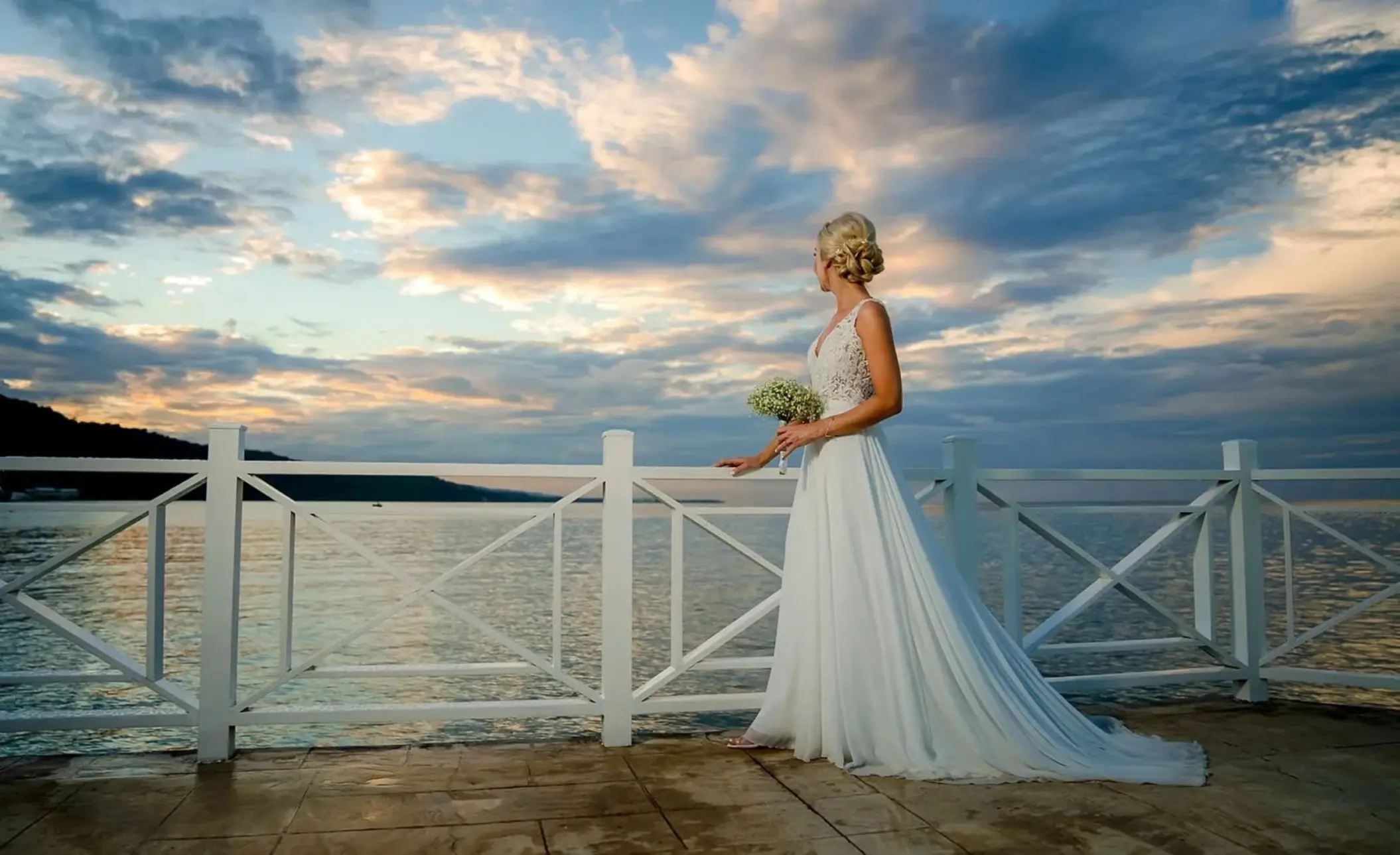 Bride holding a bouquet by the ocean at sunset at Moon Palace Jamaica, Ocho Rios