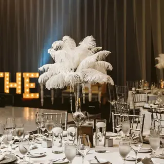 Ballroom wedding reception setup with feather centerpieces and light-up letters at Moon Palace Jamaica, Ocho Rios