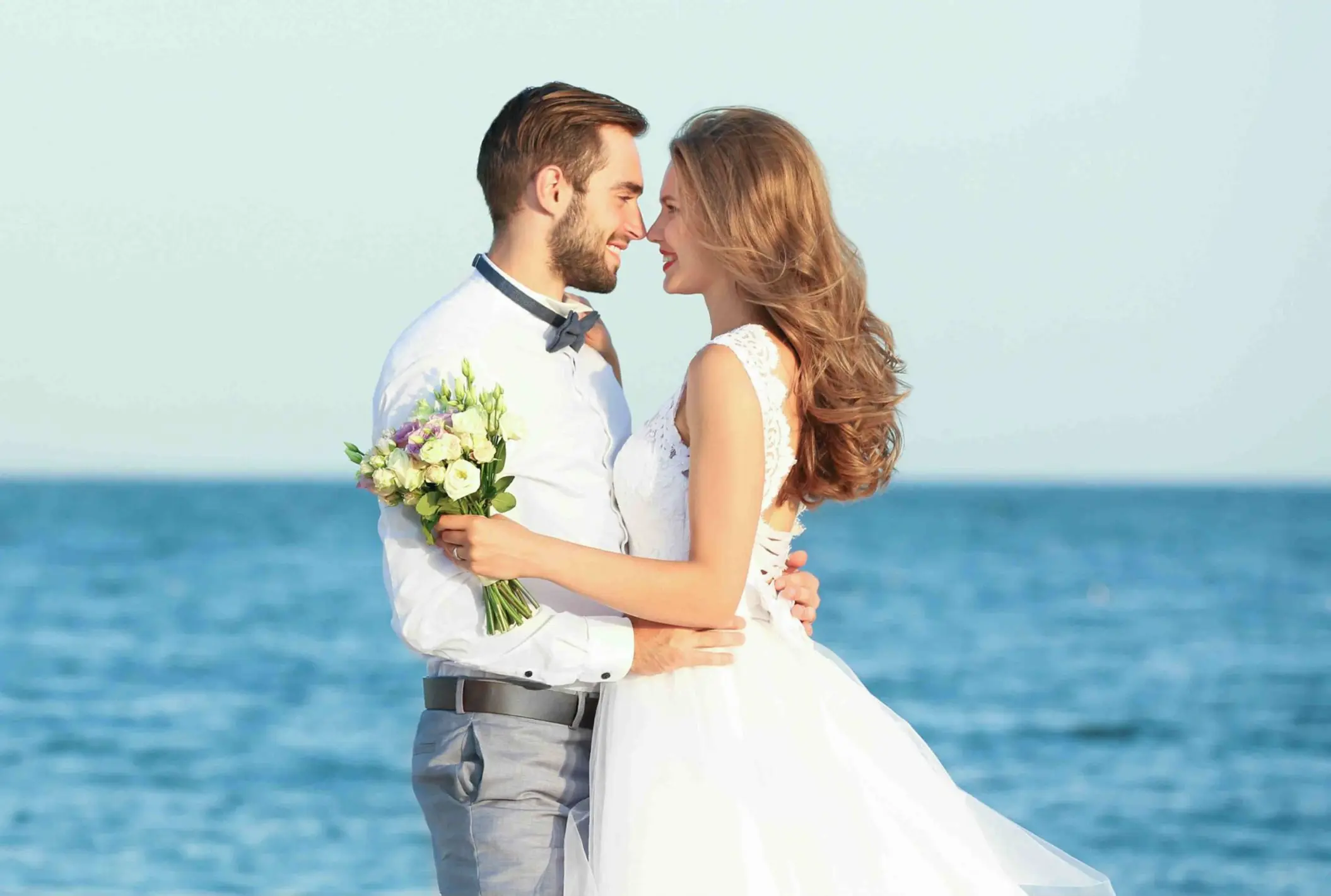 Bride and groom embracing by the ocean at Mystique Holbox, Isla Holbox