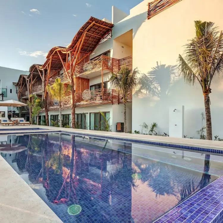 Mystique Holbox pool and suites with thatched roof accents, Isla Holbox
