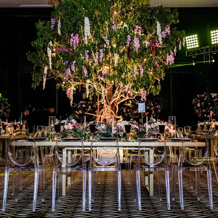 Indoor wedding reception at Nizuc Resort, Cancun featuring a large floral tree centerpiece and clear ghost chairs