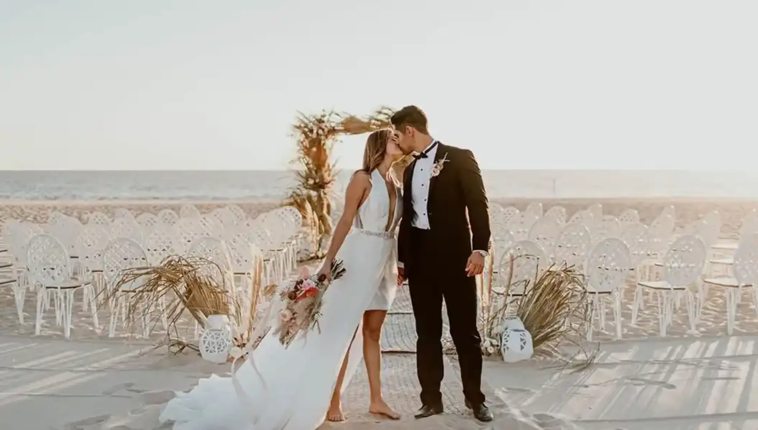 Bride and groom kissing at a beach ceremony venue at Nobu Hotel Los Cabos, Cabo San Lucas