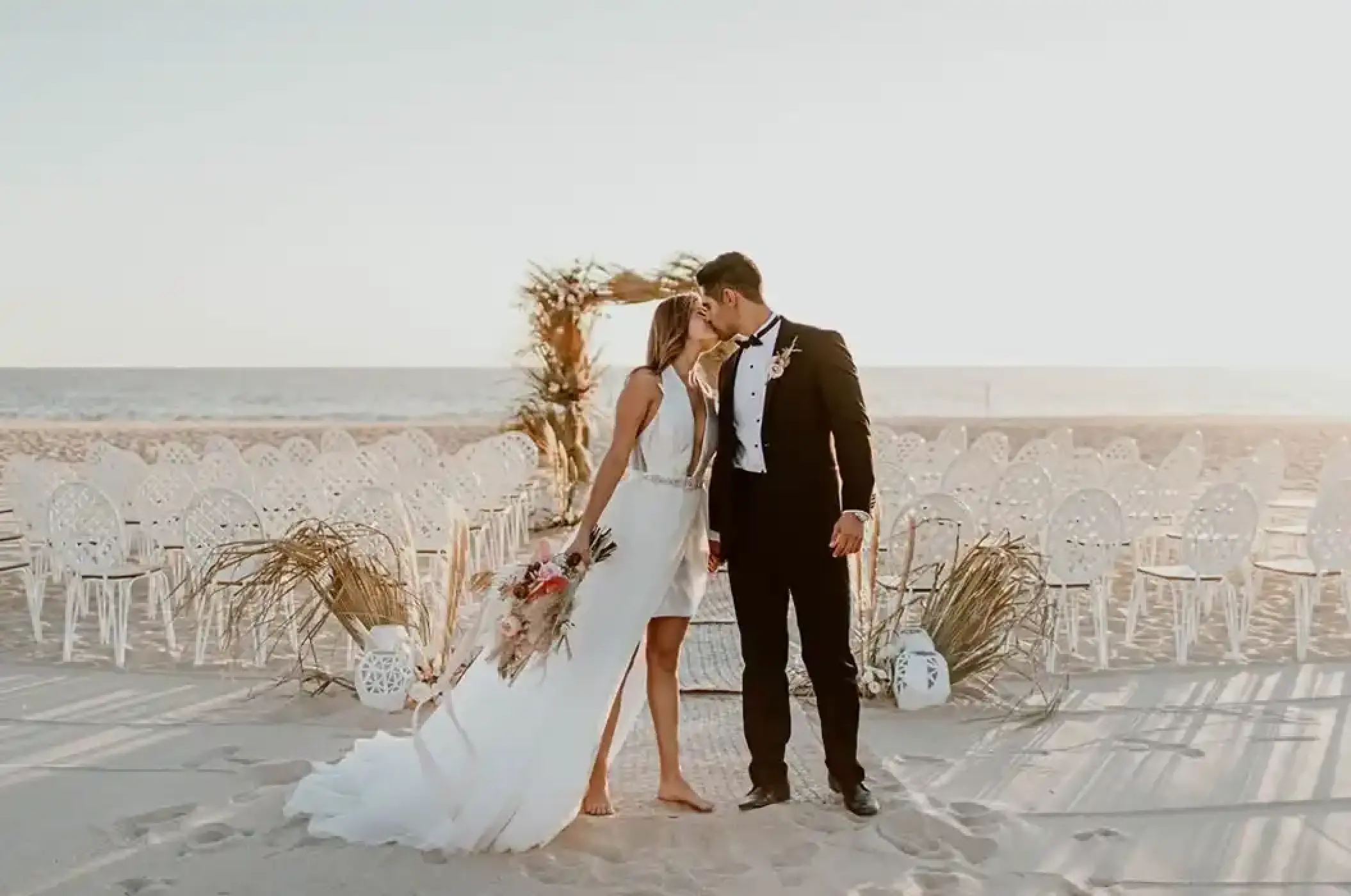 Bride and groom kissing at a beach ceremony venue at Nobu Hotel Los Cabos, Cabo San Lucas