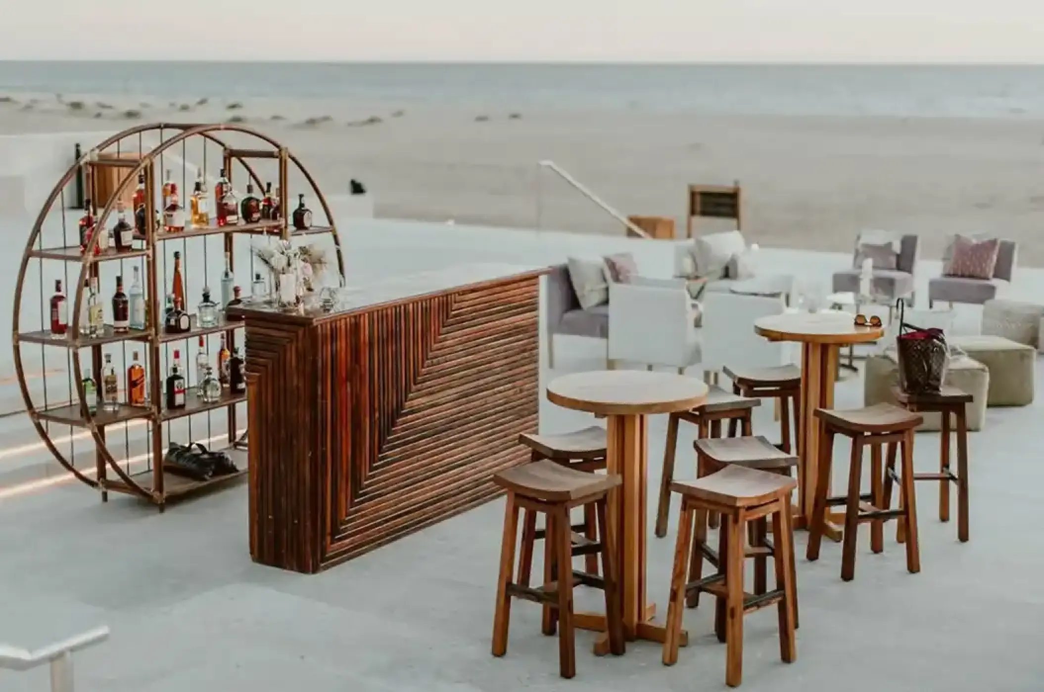 Wedding cocktail party setup with a wooden bar and circular shelf at Nobu Hotel, Cabo San Lucas