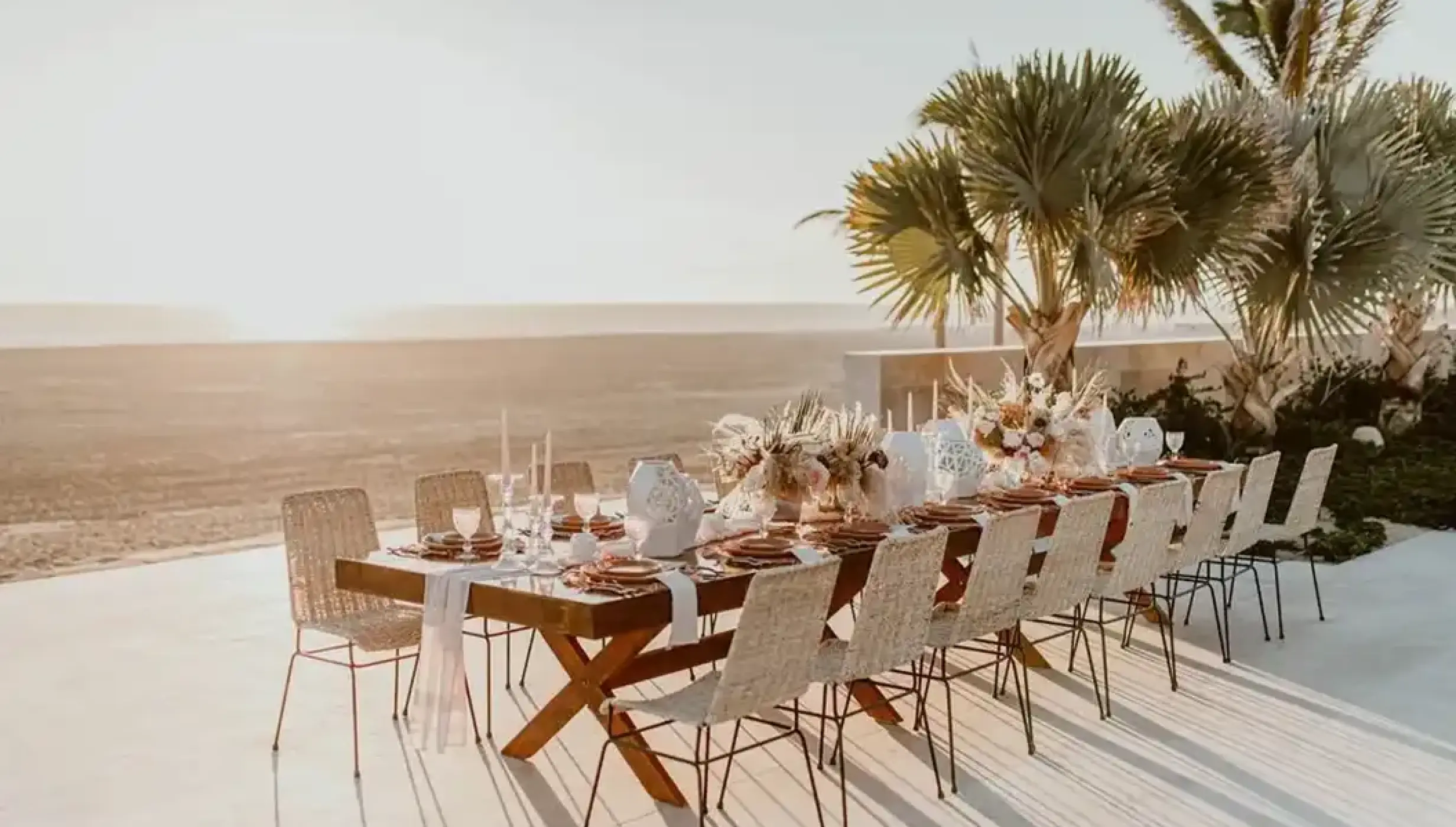 Outdoor wedding reception table with floral centerpieces overlooking the beach at Nobu Hotel Los Cabos