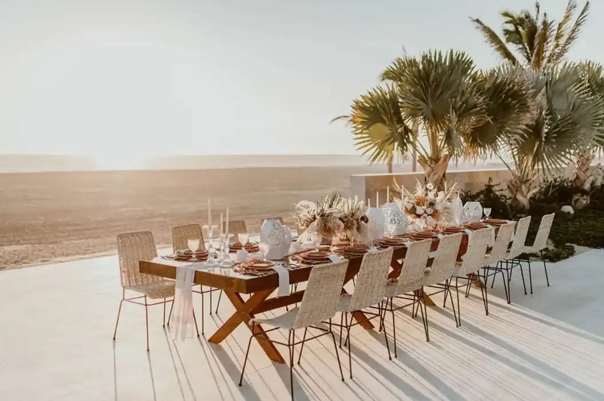Outdoor wedding reception table with floral centerpieces overlooking the beach at Nobu Hotel Los Cabos