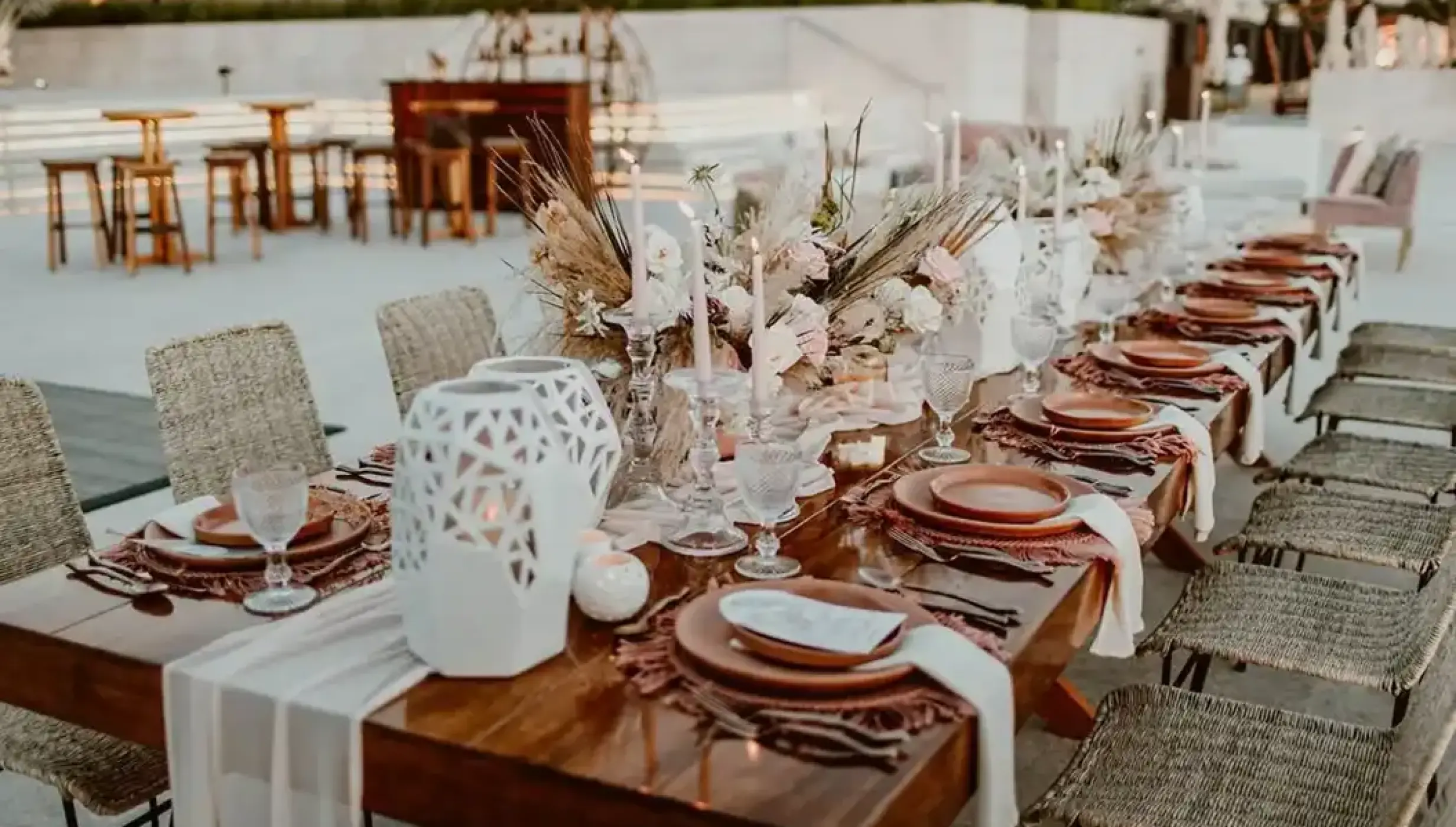 Long wooden wedding reception table with boho floral centerpieces at Nobu Hotel Los Cabos, Cabo San Lucas