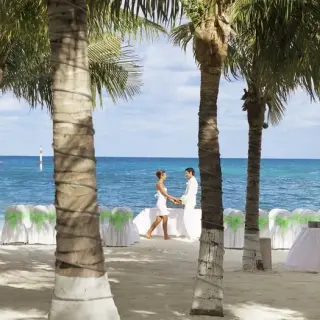 Bride and groom standing at their beachfront wedding ceremony at Occidental Costa Cancun