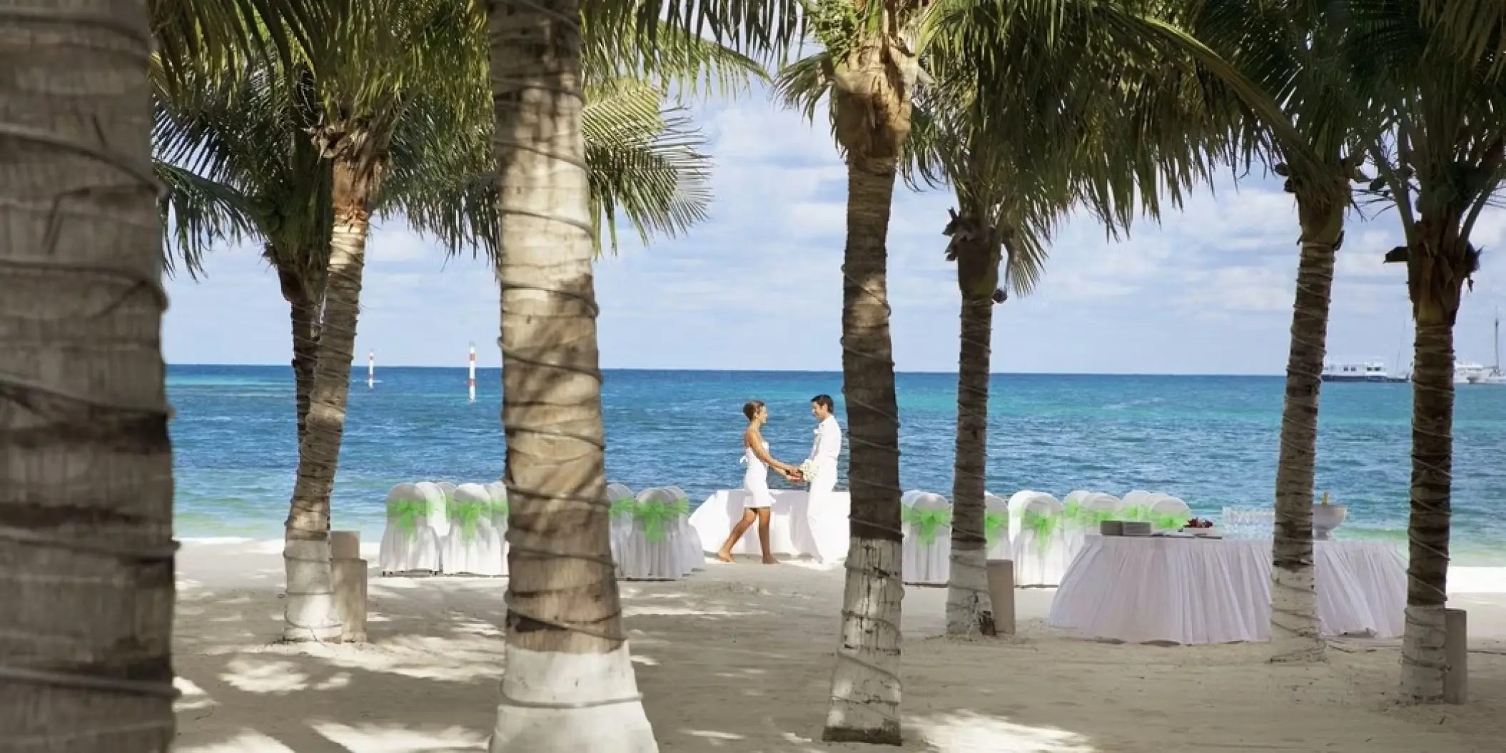 Bride and groom standing at their beachfront wedding ceremony at Occidental Costa Cancun