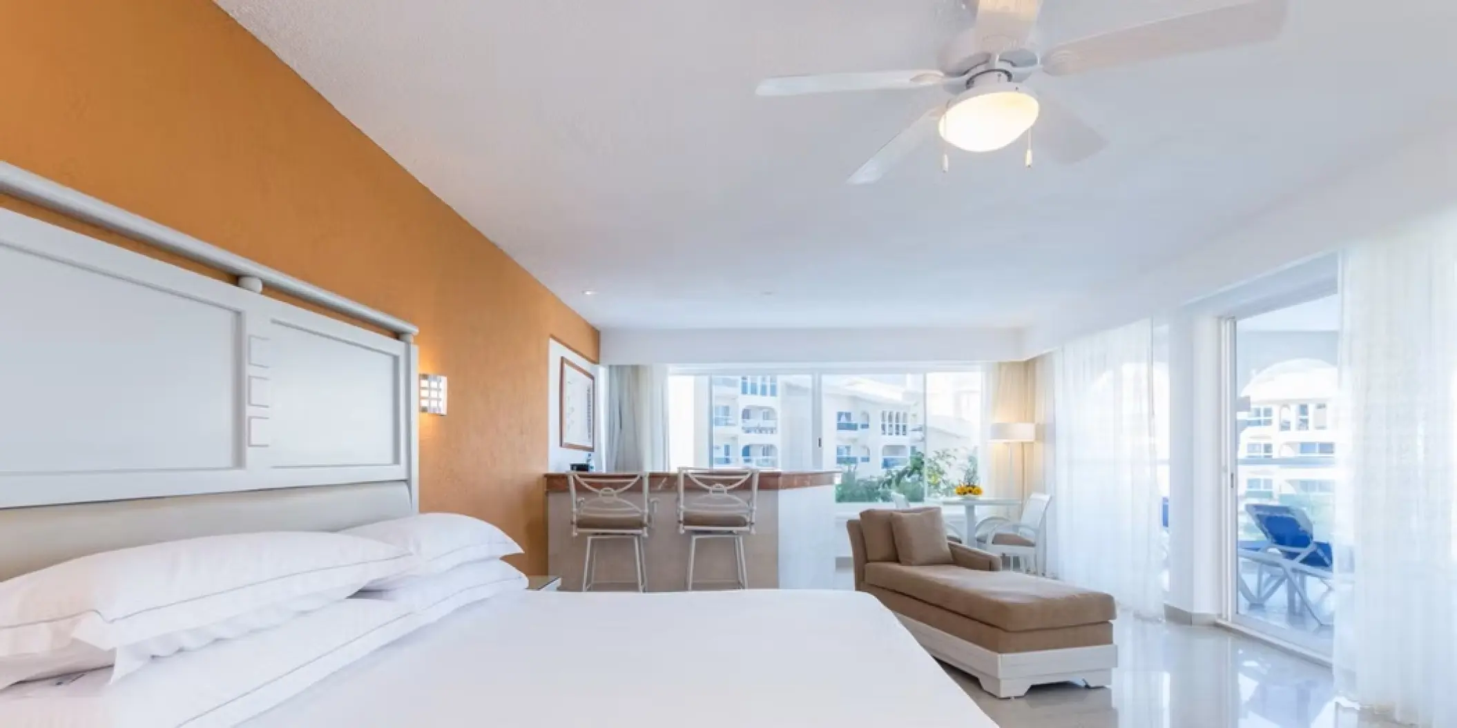 White and orange guest suite with a balcony at Occidental Costa Cancun