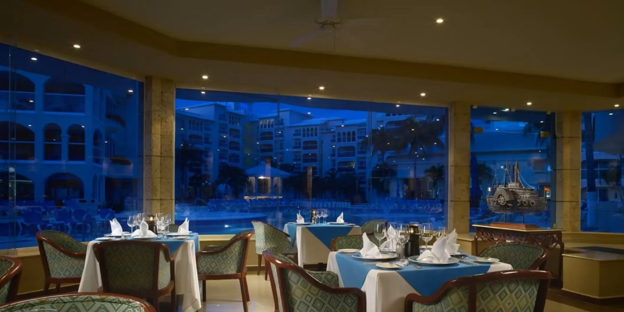 Indoor poolside restaurant at Occidental Costa Cancun overlooking the pool at night, Cancun