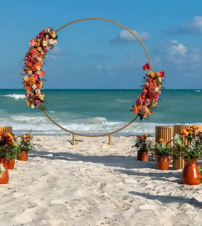 Circular floral arch for a beachfront wedding ceremony at Ocean Allure Costa Mujeres, Cancun