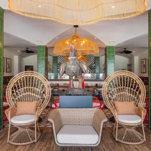 Restaurant lounge with wicker peacock chairs and green tiled pillars at Ocean Allure Costa Mujeres, Cancun