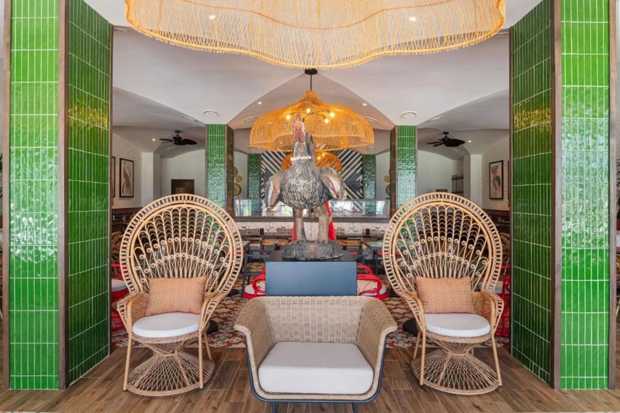 Restaurant lounge with wicker peacock chairs and green tiled pillars at Ocean Allure Costa Mujeres, Cancun
