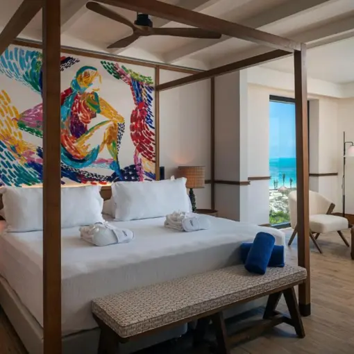 Poster bed suite with ocean views and colorful wall art at Ocean Allure Costa Mujeres, Cancun