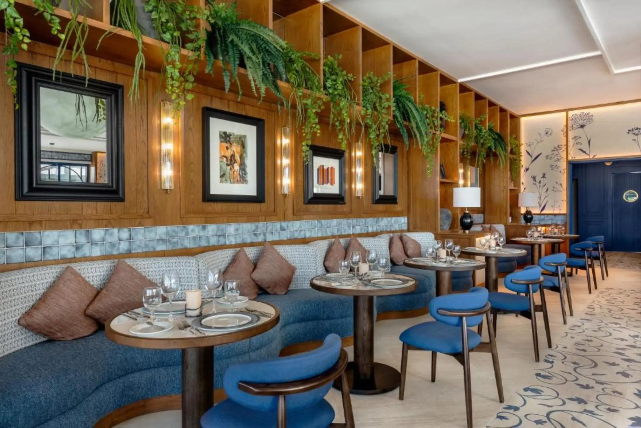 Modern restaurant dining room with blue booth seating and wood paneled walls at Ocean Allure Costa Mujeres, Cancun