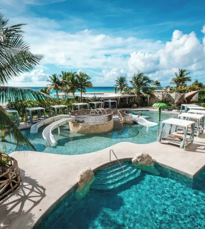 Outdoor pools with cabanas and palm trees at Palmaia House of AiA, Playa Del Carmen