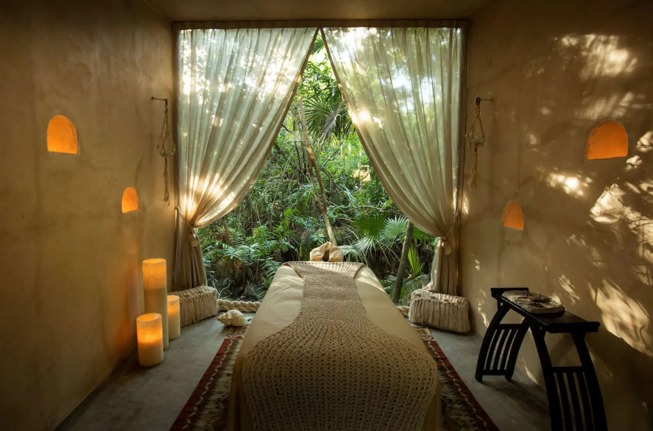 Spa treatment room with a massage table and jungle views at Palmaia The House of AiA, Playa Del Carmen