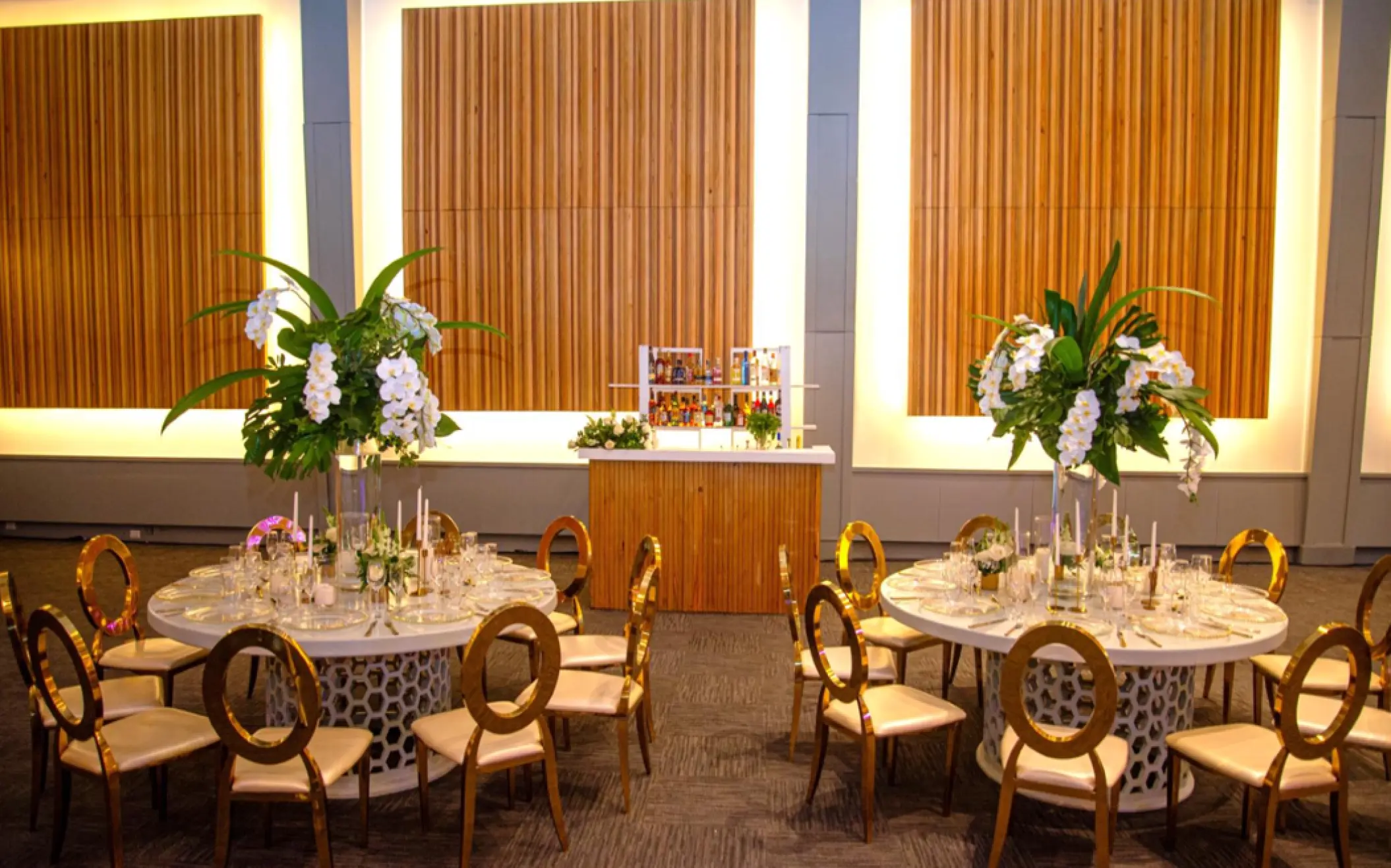 Indoor wedding reception setup with gold chairs and white floral centerpieces at Paradisus Palma Real, Punta Cana