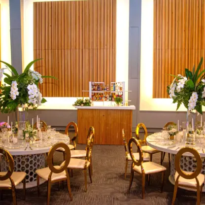 Indoor wedding reception setup with gold chairs and white floral centerpieces at Paradisus Palma Real, Punta Cana