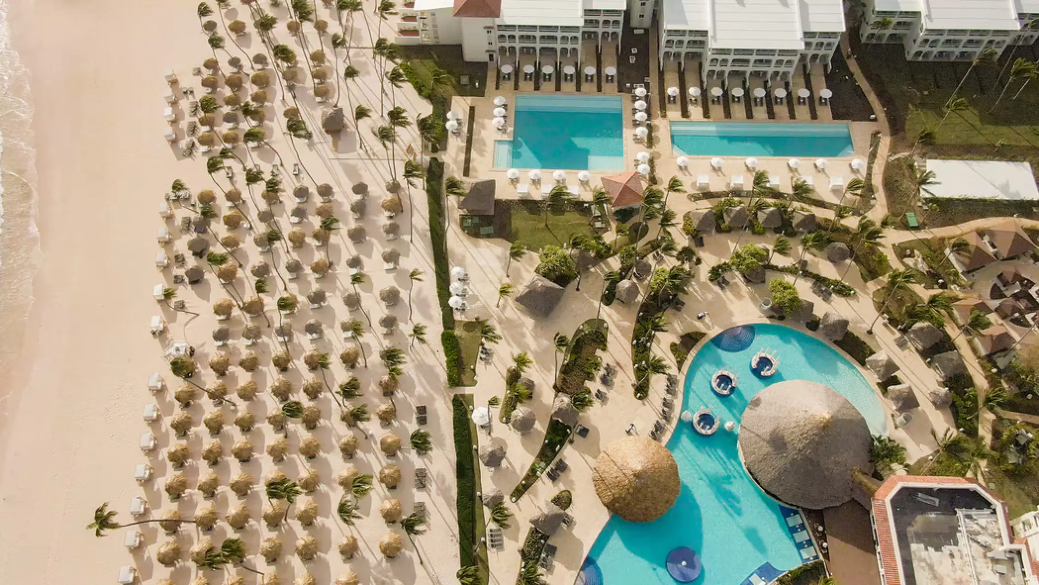 Aerial view of pools and thatched beach umbrellas at Paradisus Palma Real, Punta Cana