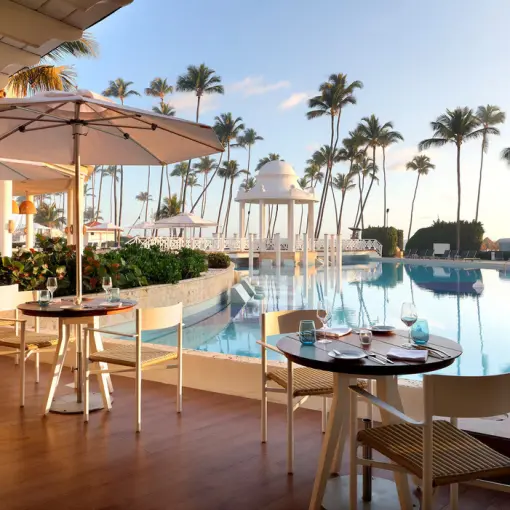 Poolside restaurant terrace with white umbrellas at Paradisus Palma Real, Punta Cana