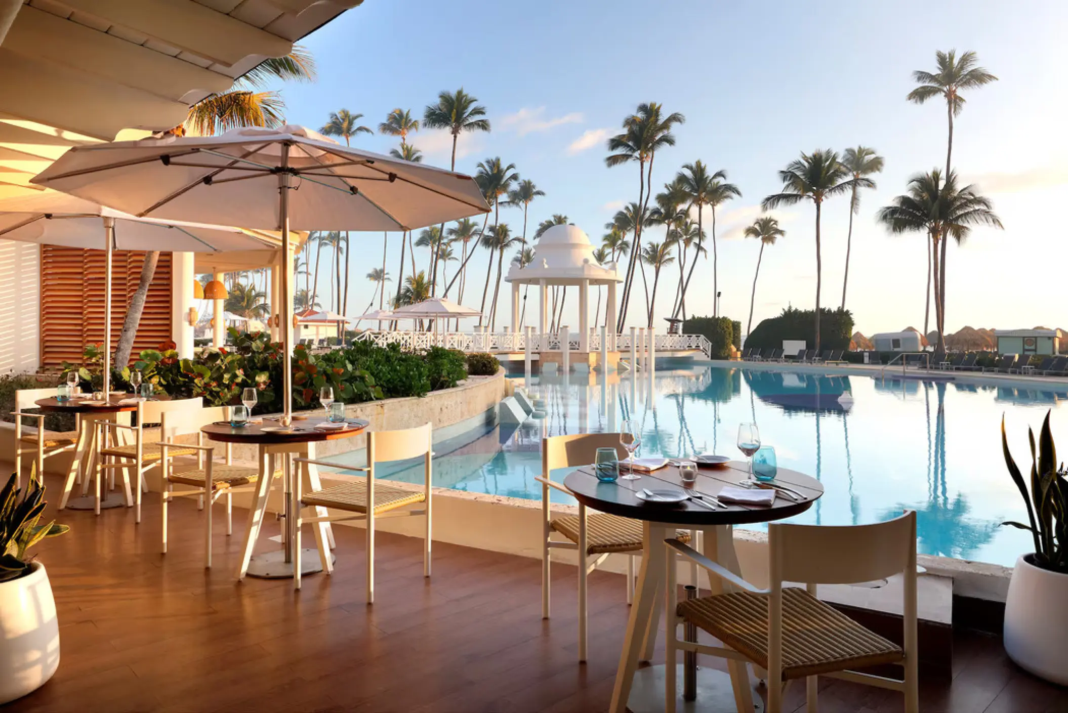Poolside restaurant terrace with white umbrellas at Paradisus Palma Real, Punta Cana