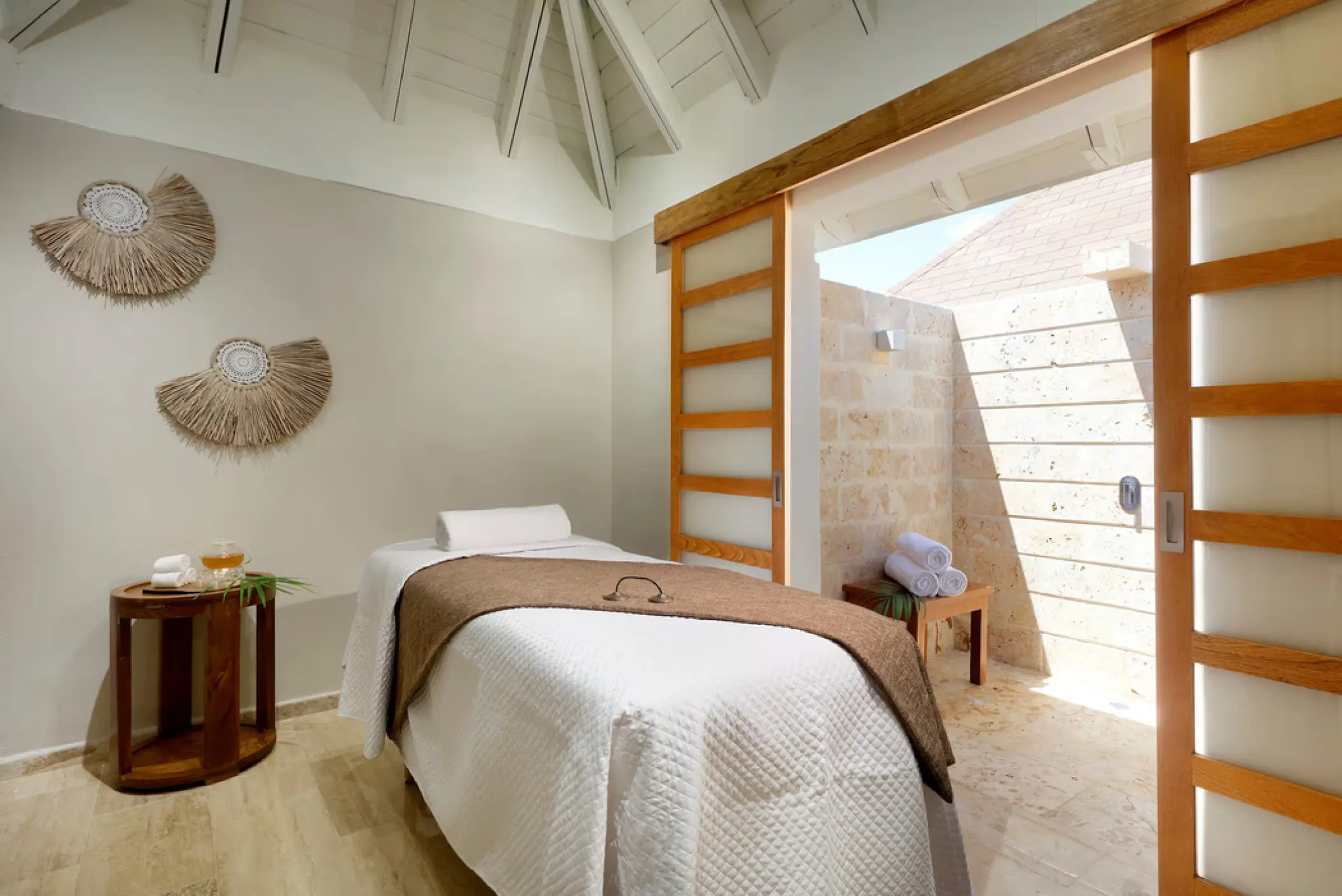 Spa treatment room with a massage table and outdoor shower at Paradisus Palma Real, Punta Cana