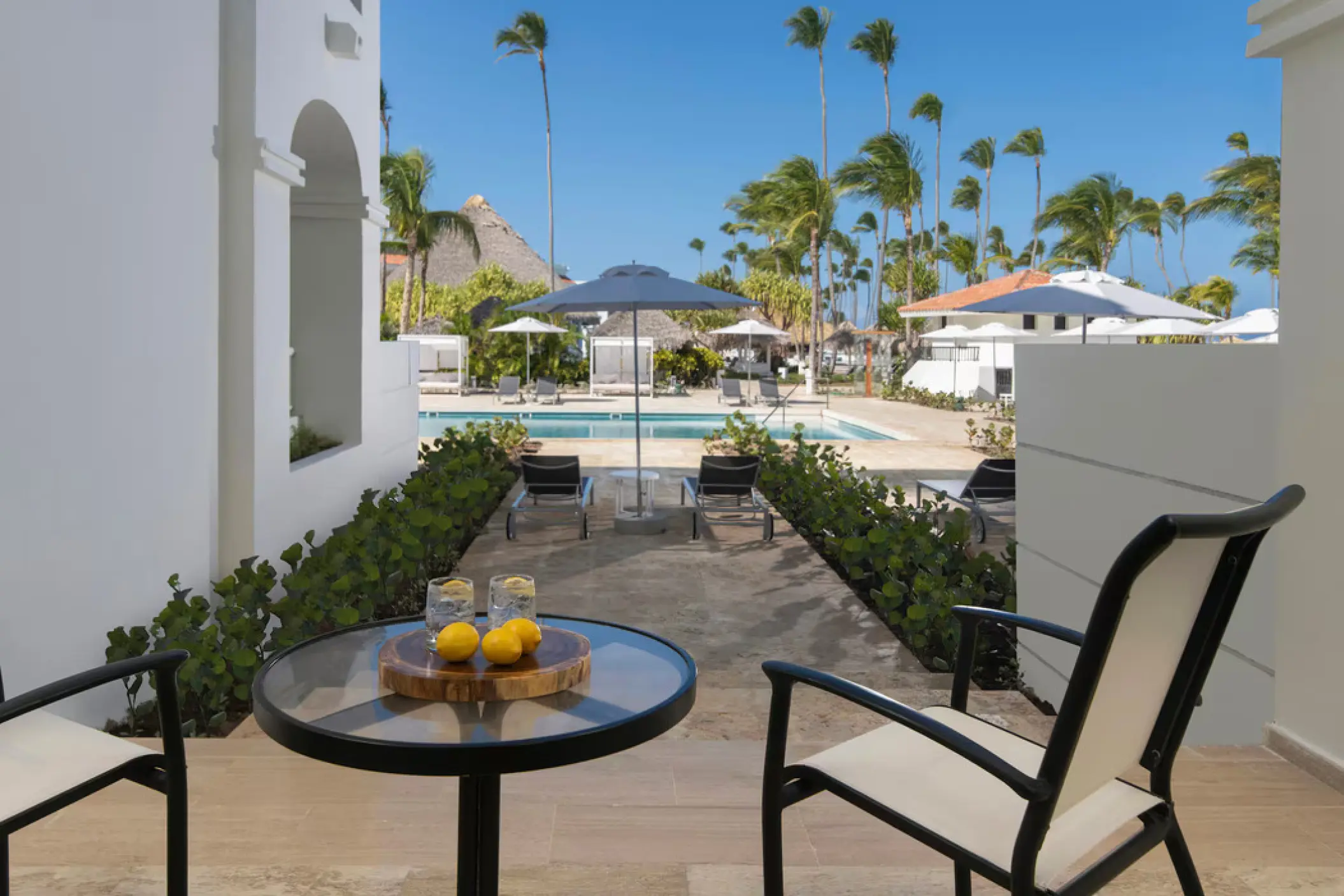 Private suite terrace overlooking the pool and palm trees at Paradisus Palma Real, Punta Cana