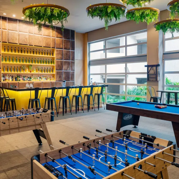 Indoor games room with foosball tables, a pool table, and a bar at Paradisus Playa Del Carmen